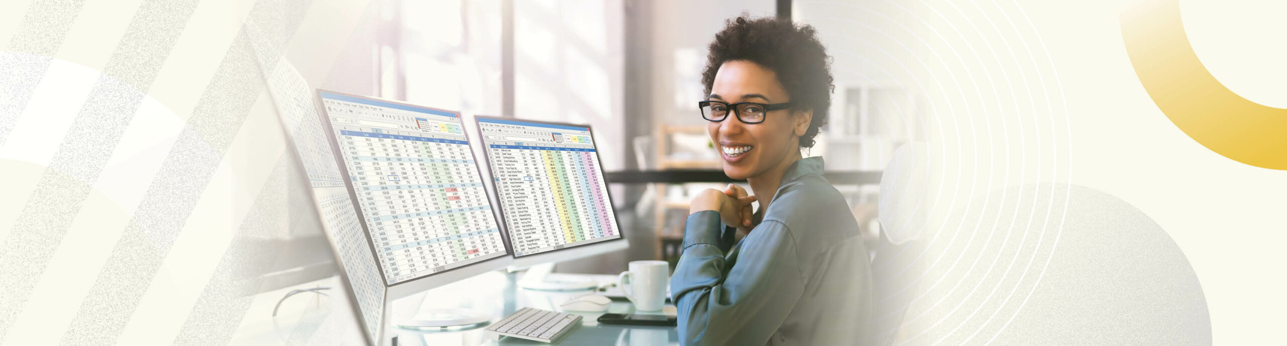 Image of a young African American business professional studying spreadsheets on her computer and smiling